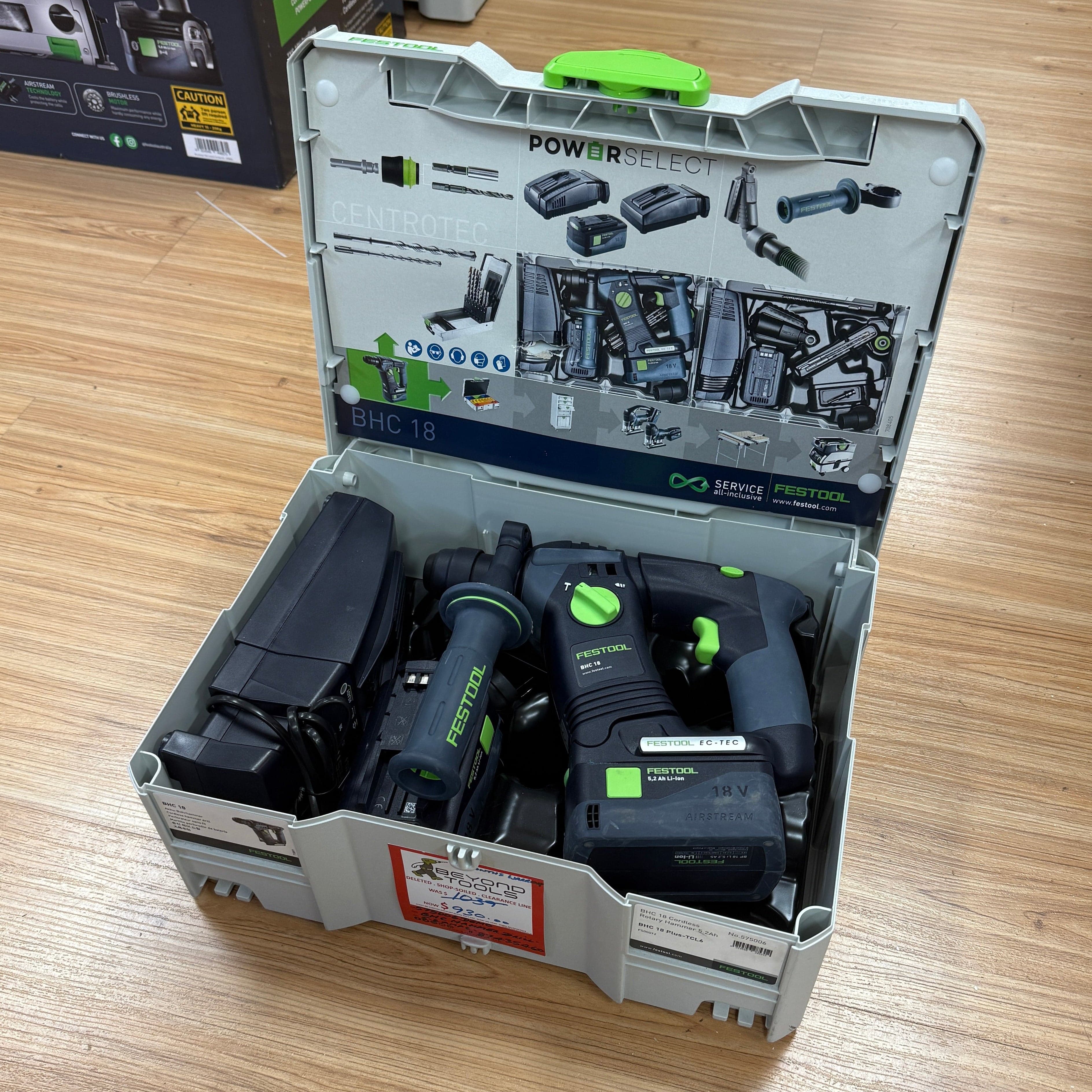 Open tool case with power tools and accessories on a wooden surface