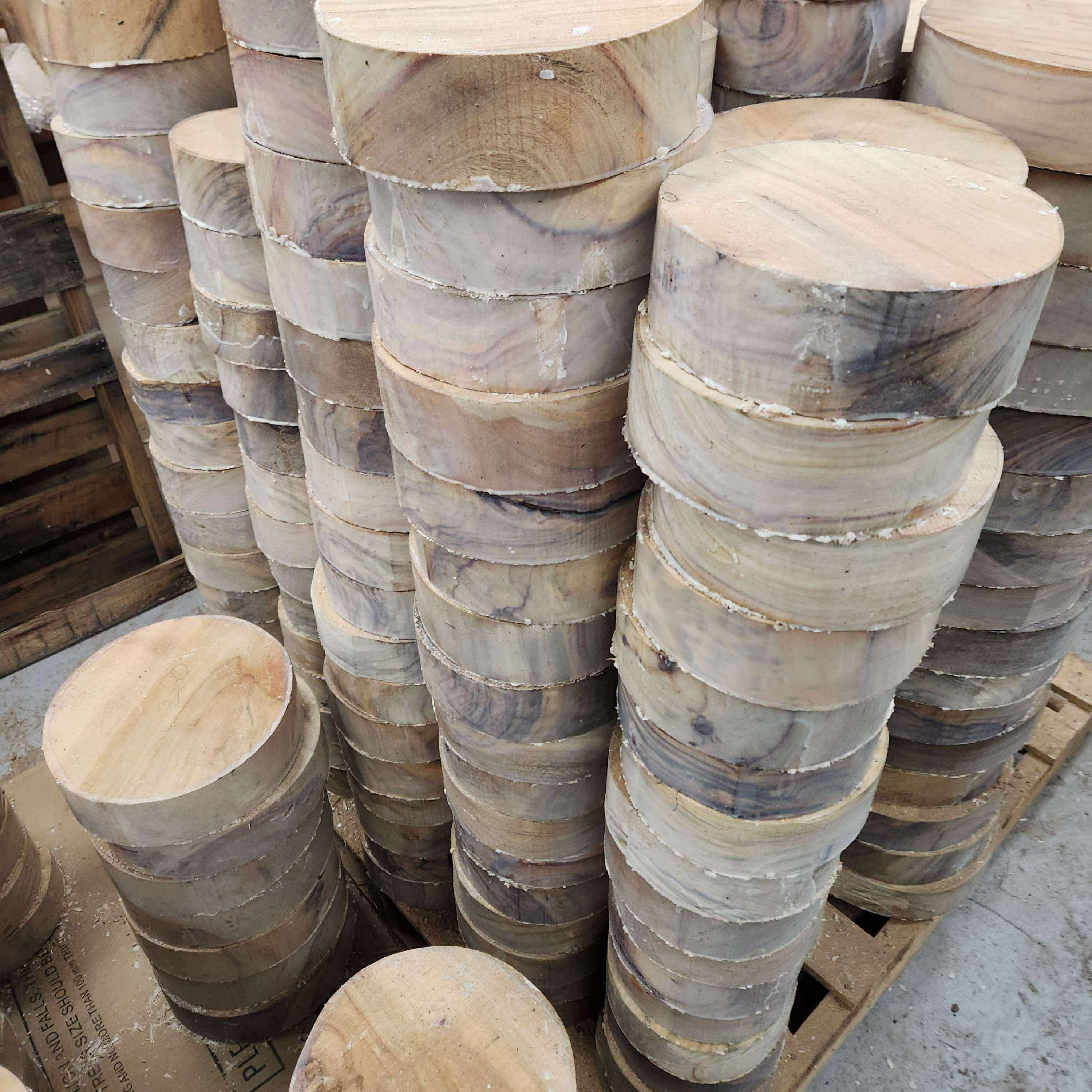 Stacks of wooden rounds on a pallet in an indoor setting